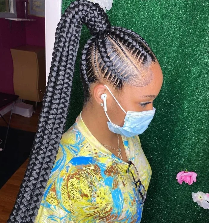 Black hair cornrows styled into high ponytail, sleek and protective braided hairstyle.