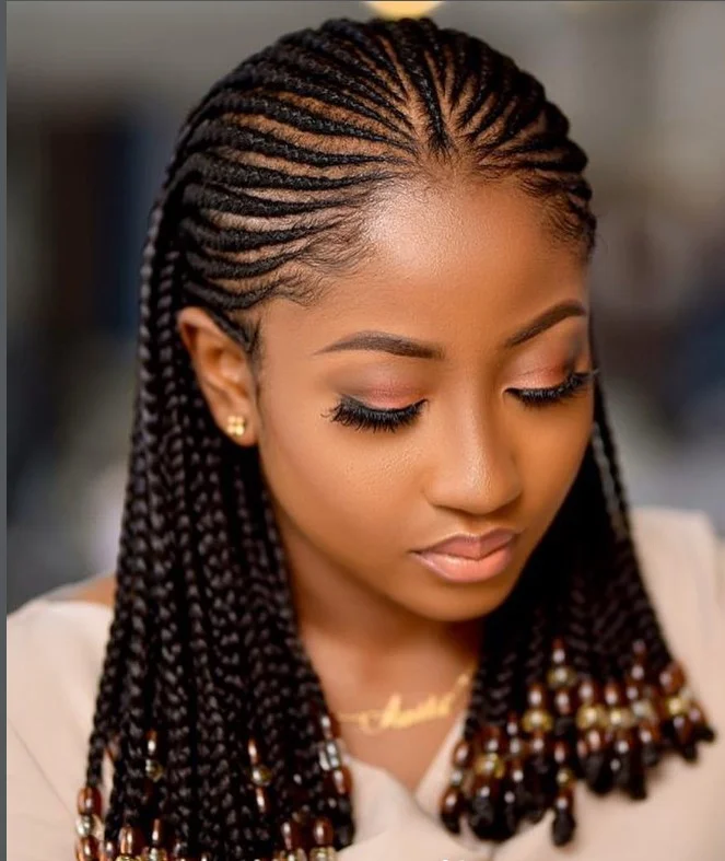 Cornrows on black hair adorned with colorful beads for cultural and festival-ready hairstyle.