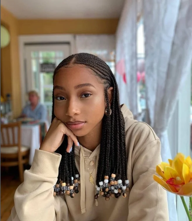 Cornrows with box braids hairstyle decorated with beads and accessories