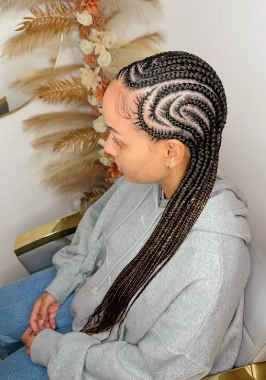 Curved cornrow braids on black hair with flowing design for artistic protective hairstyle.