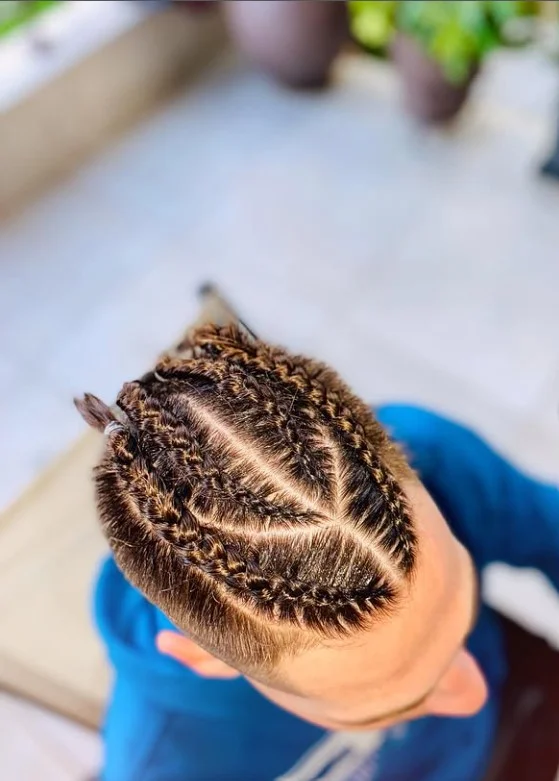 Curved pattern 4 cornrow braids hairstyle featuring artistic scalp design and flowing braid structure