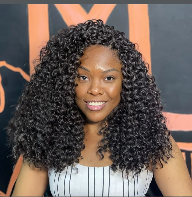 Side part crochet braids hairstyle with sleek edges and layered curls