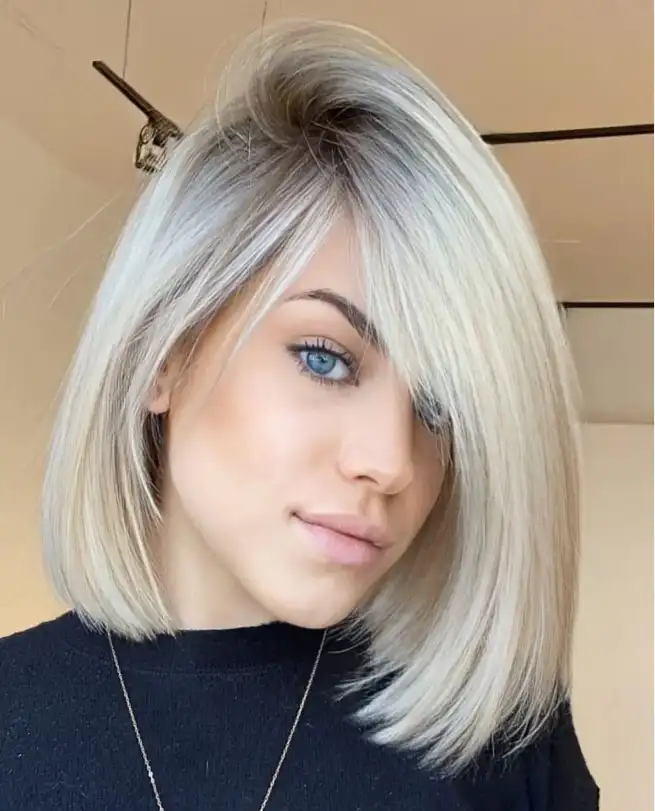 Angled medium bob hairstyle with side swept bangs sharp cut with soft front layers