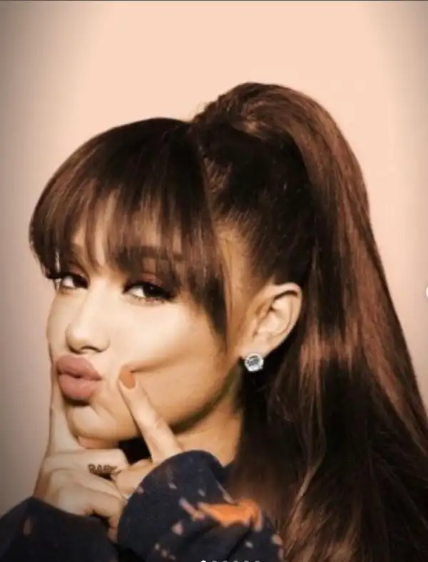 Ariana Grande high ponytail with soft bangs, combining a sleek pulled-back look with face-framing fringe for a playful yet sharp style.