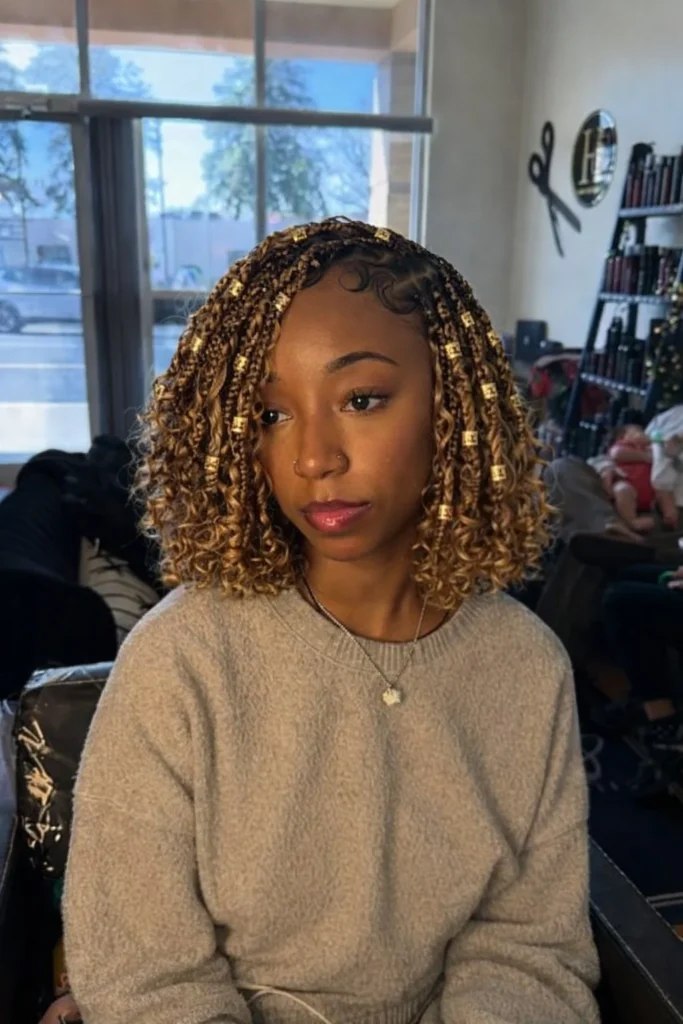 Fashionable bob braids hairstyle with hair cuffs 2026 featuring metallic accessories decorating a stylish braided bob.