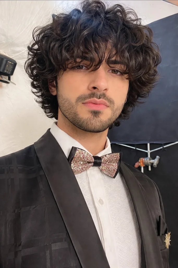 Curly hairstyle for guys with long bangs and volume