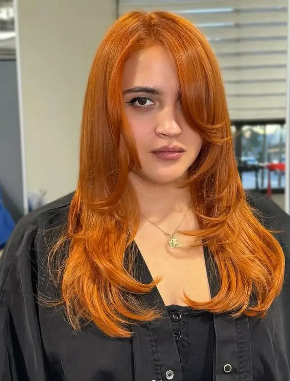 Face framing layered hairstyle with side bangs for round face soft look