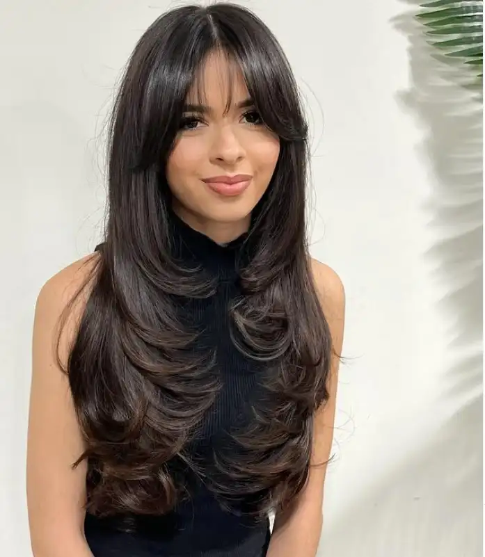 Face framing layered hairstyle with wispy bangs soft look