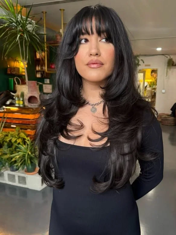 Long layered hairstyle with soft wispy bangs natural volume