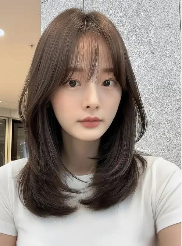 Medium layered hairstyle with see-through bangs soft style