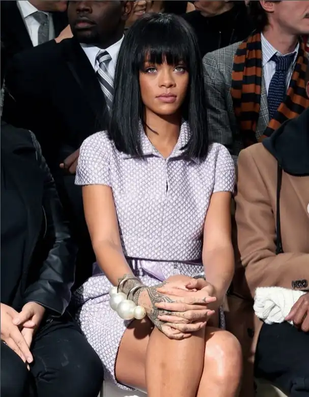 Rihanna blunt bangs cut straight across the forehead, creating a bold, sleek hairstyle that highlights the eyes and adds dramatic edge.