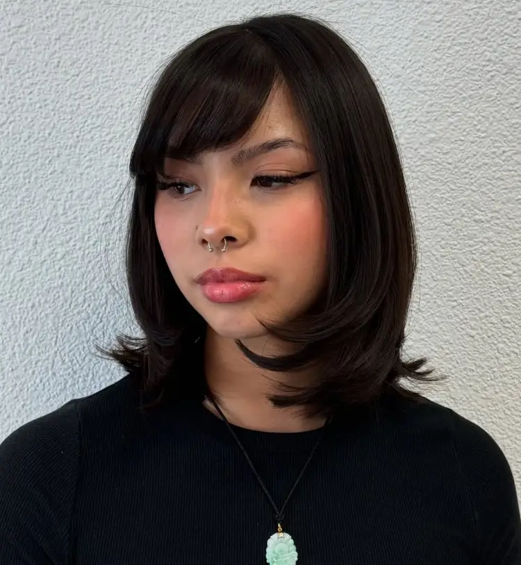 Shoulder length layered hairstyle with side bangs for round face soft look