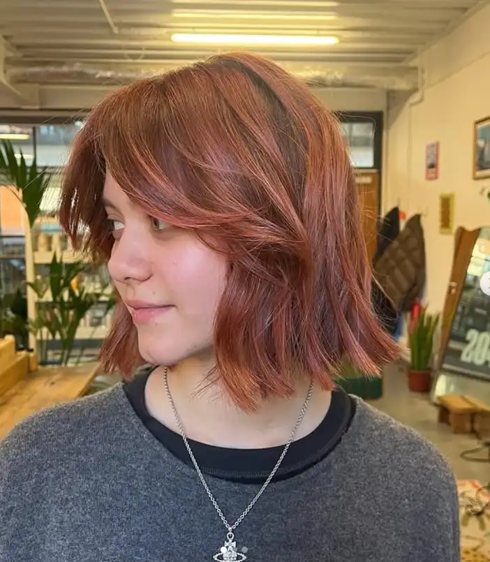 Tousled medium bob hairstyle with side swept bangs relaxed waves and soft texture