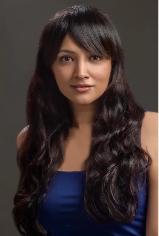 Wavy hairstyle with side bangs for round face soft volume look