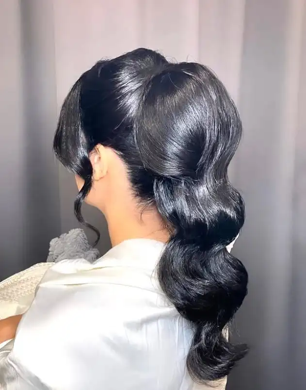 Black hairstyle wavy ponytail with side bangs relaxed modern look