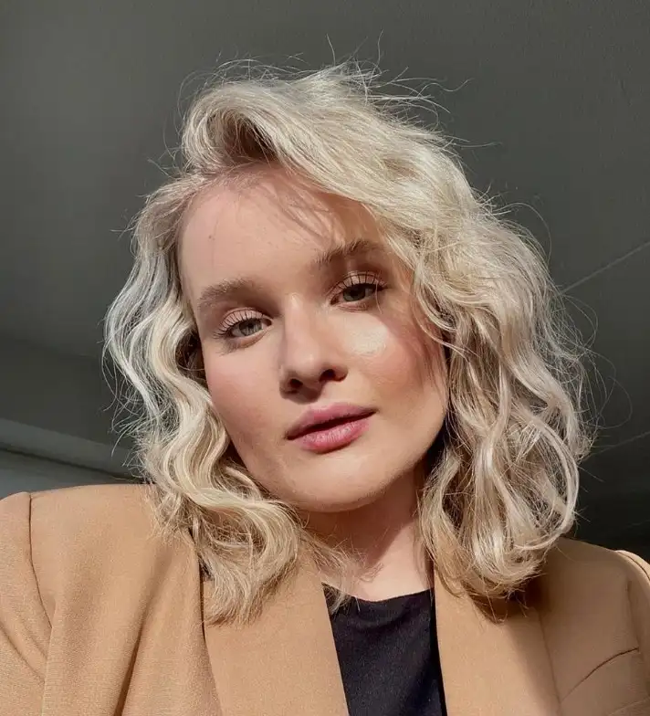 Wavy shoulder length layered hairstyle with side bangs beachy style