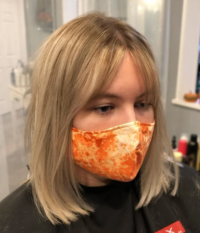 Blunt blonde bob hairstyle with side fringe sharp modern finish