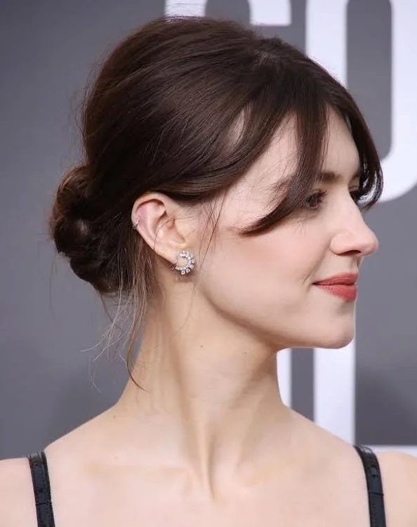 Classic low bun hairstyle with side bangs elegant soft look