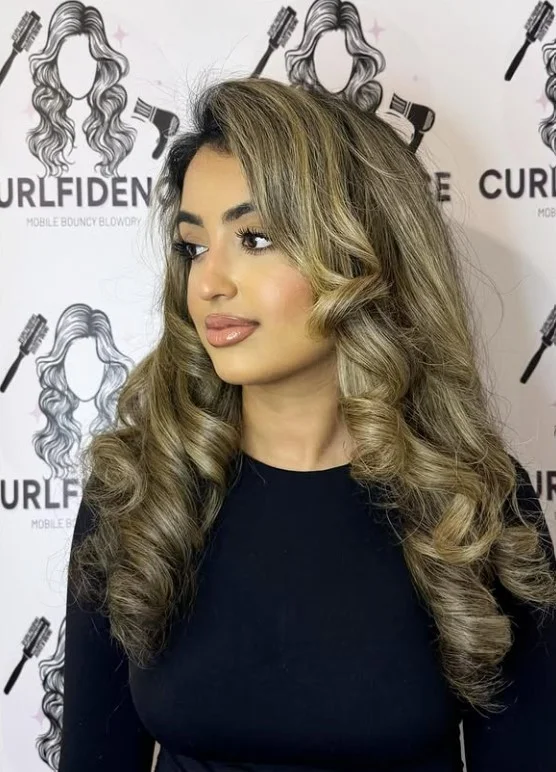Face framing curly hairstyle with side bangs flattering soft look