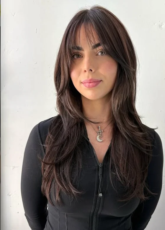 Face framing long layered hairstyle with curtain bangs flattering style