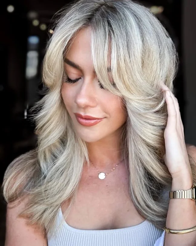 Feathered blonde layered hairstyle with side bangs airy soft look