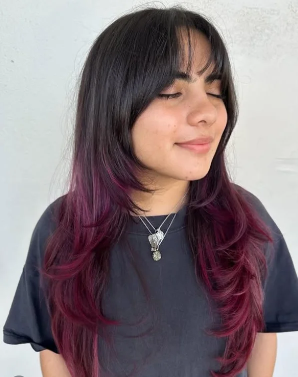 Feathered long layered hairstyle with curtain bangs airy movement style