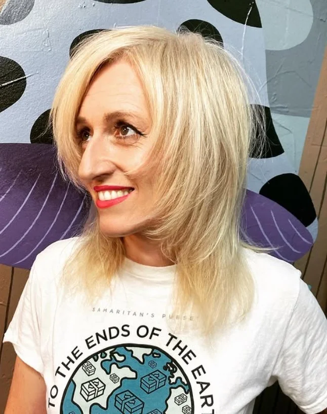 Fine blonde hairstyle with side bangs adding volume and fullness