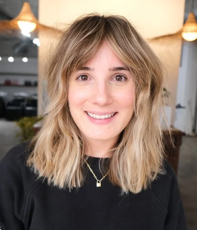 Layered blonde lob hairstyle with side fringe trendy modern style