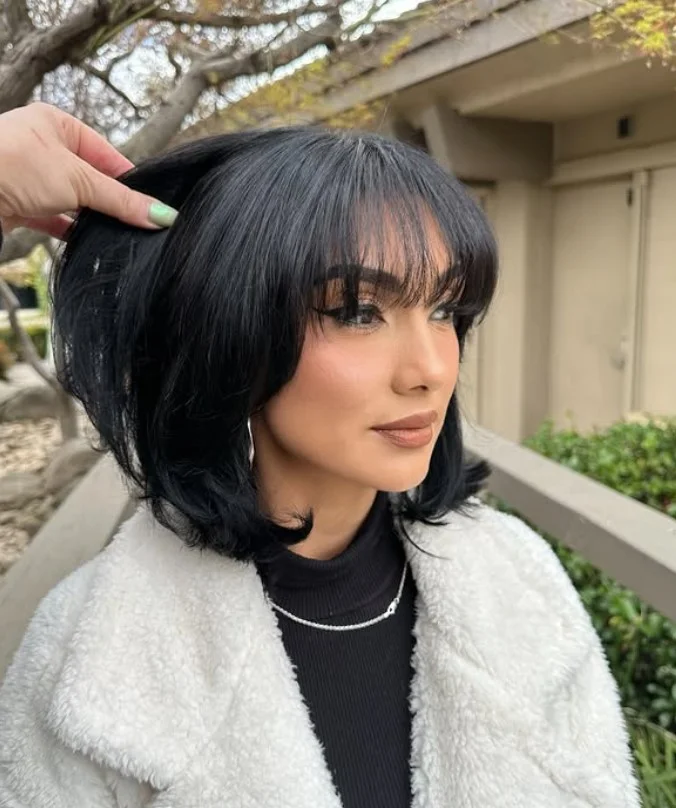 Layered bob with bangs playful hairstyle for long face
