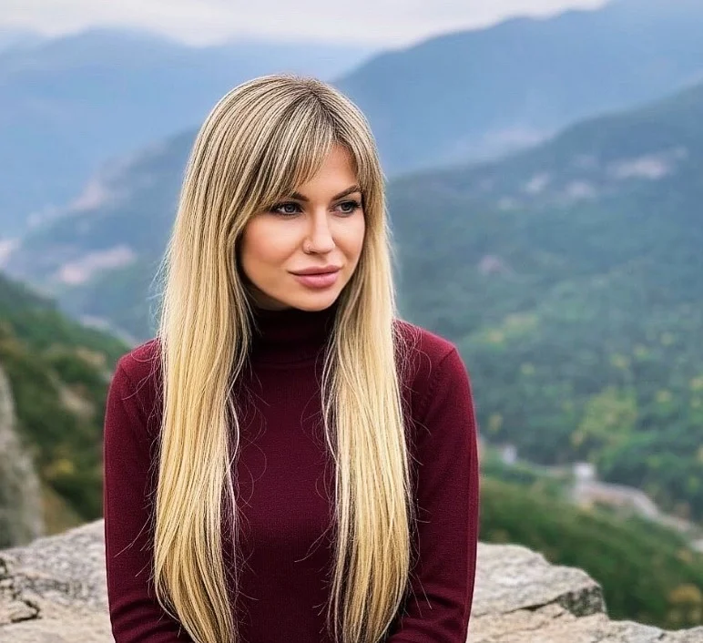 Long blonde hairstyle with side bangs smooth flowing look