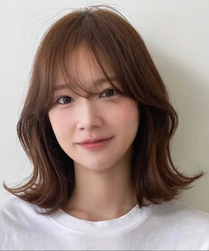 Shoulder length hair with wispy curtain bangs modern balanced look