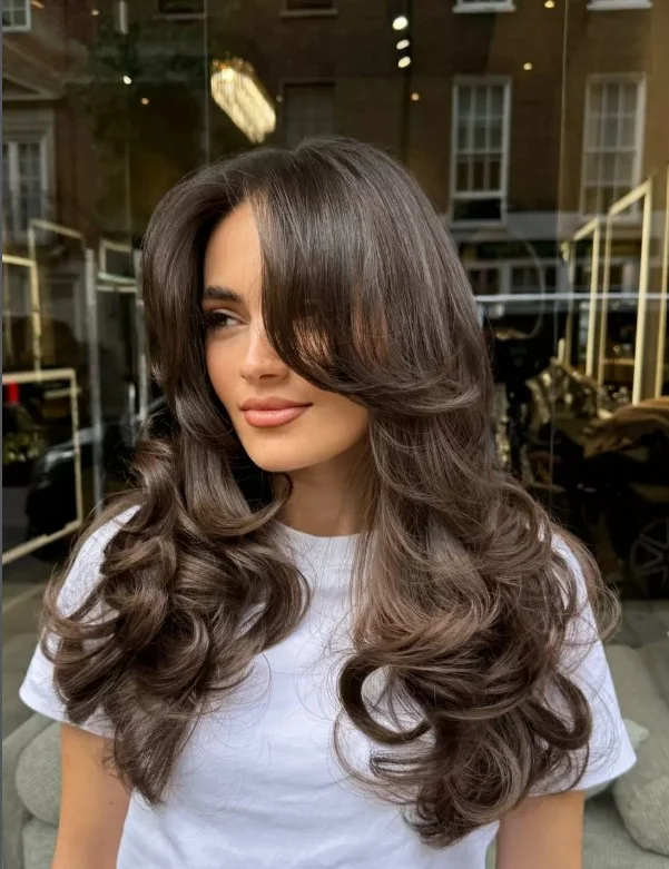 Side swept bangs with layered hairstyle for long faces