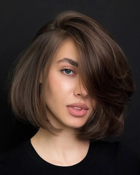Sleek layered bob hairstyle with side bangs polished smooth finish