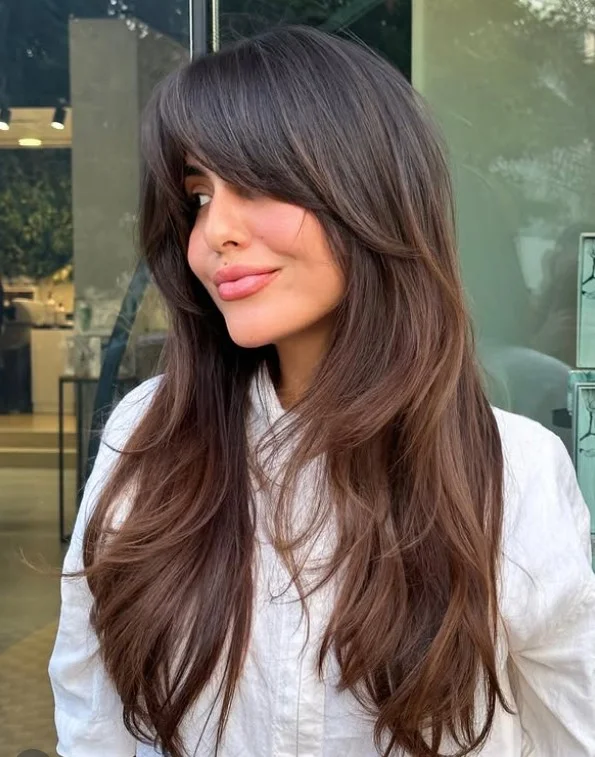 Sleek long layered hairstyle with curtain bangs smooth modern look