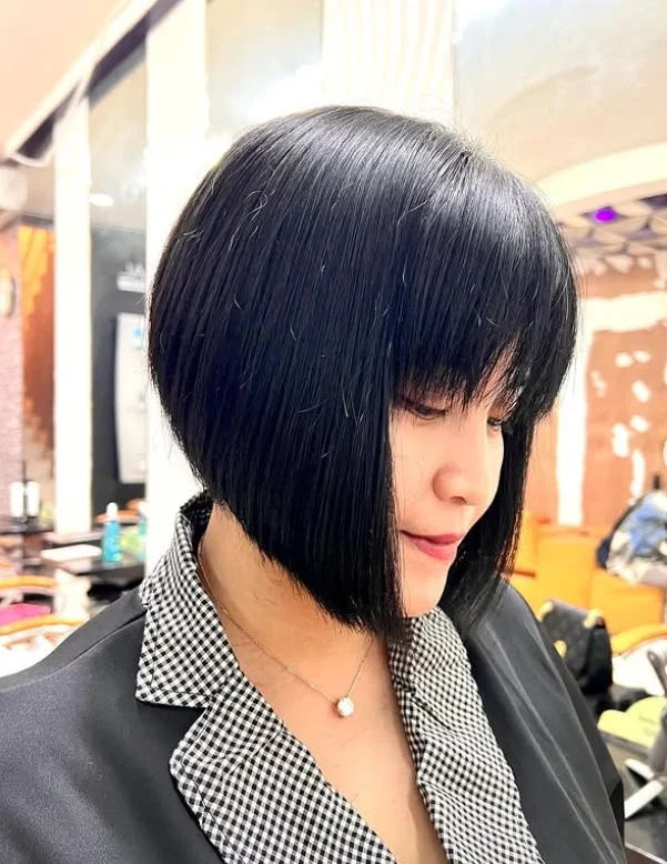 Straight inverted bob hairstyle with bangs sharp sleek finish