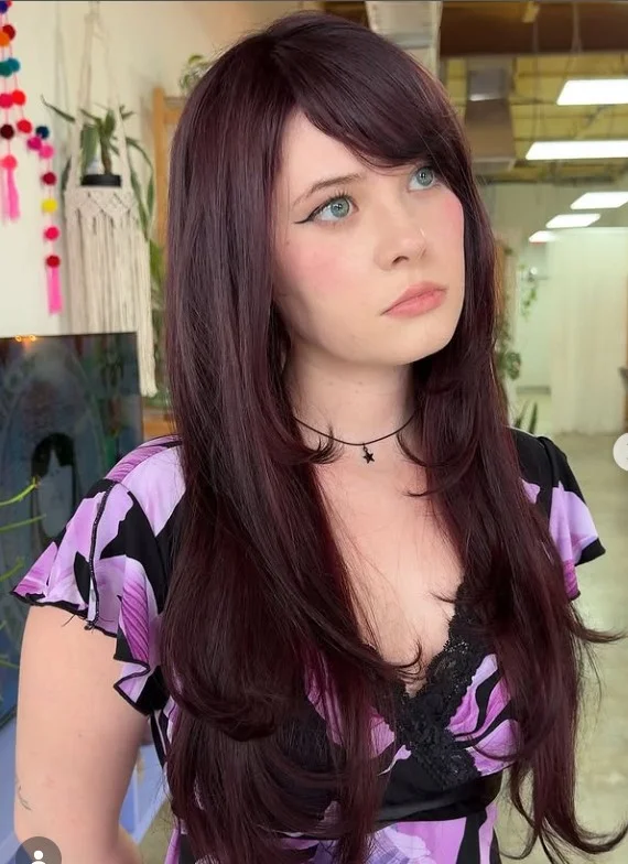 Straight long layered hairstyle with side bangs sleek polished finish