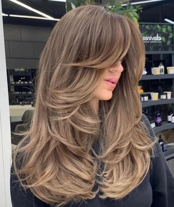 Thick hair layered hairstyle with curtain bangs balanced voluminous look