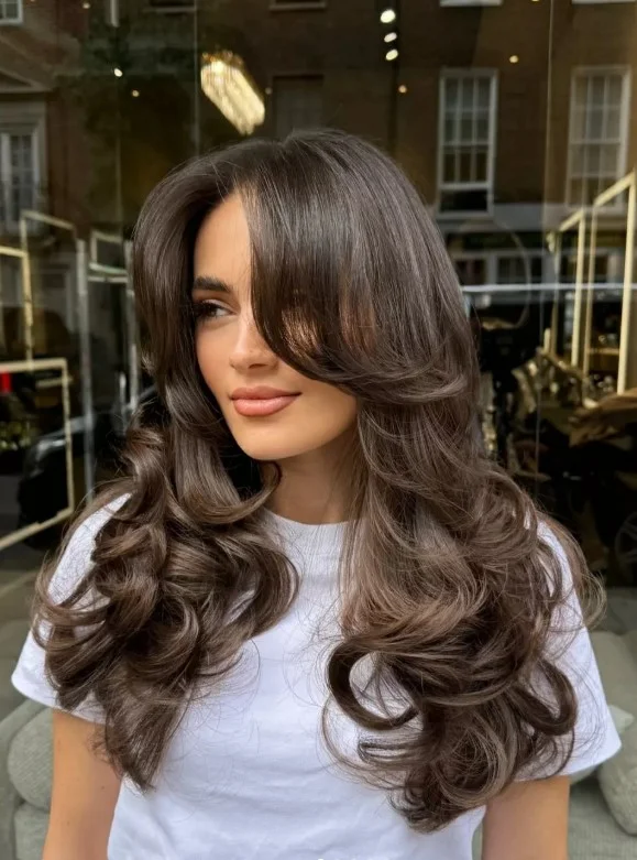 Thick hair layered hairstyle with side swept bangs balanced full look