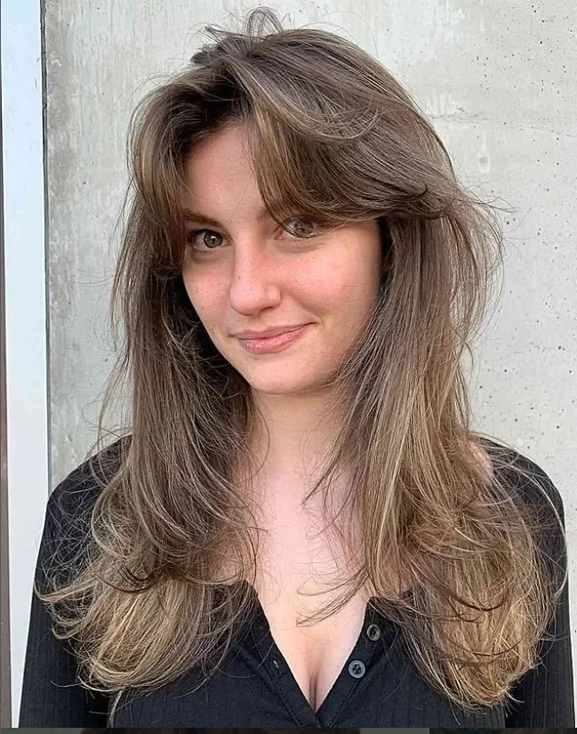 Tousled long layered hairstyle with side bangs casual stylish texture