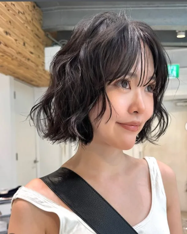 Wavy bob with bangs hairstyle adding width to long face
