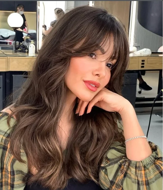 Wavy long layered hairstyle with curtain bangs romantic textured look