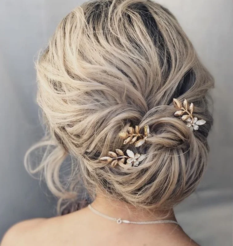 low textured bridal bun hairstyle for beach wedding look