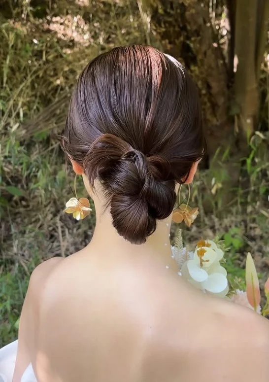 sleek low bridal bun hairstyle for elegant beach wedding