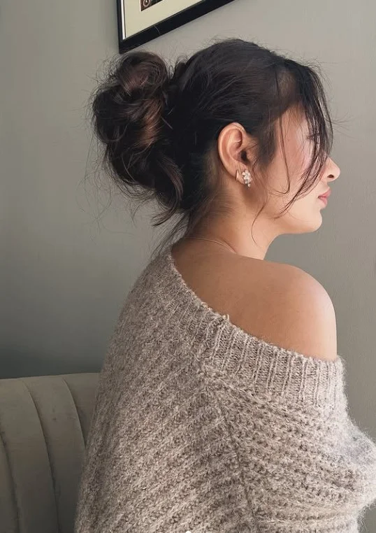 textured beach bun hairstyle with soft beach bangs