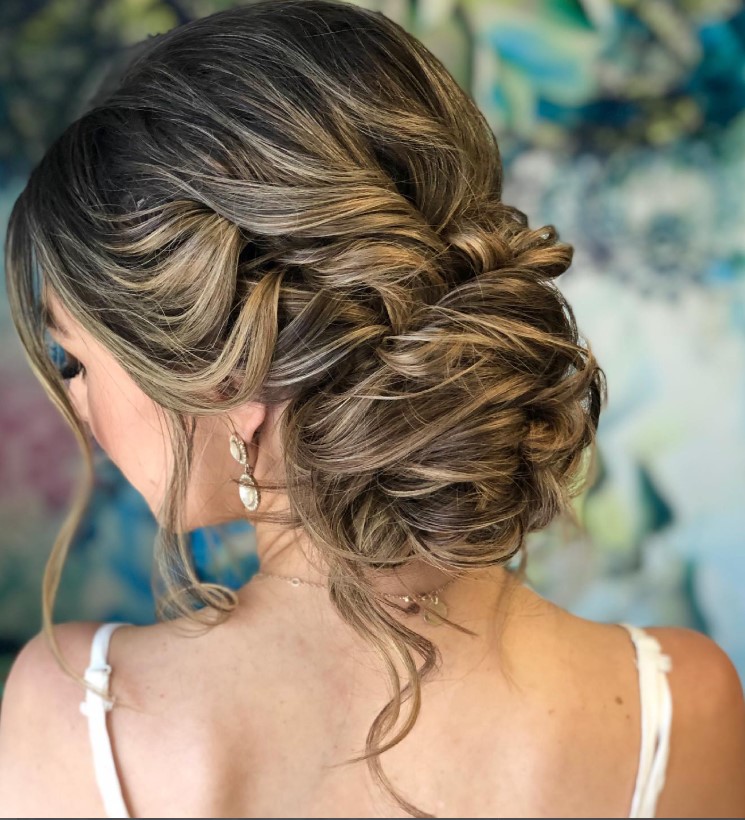 side bun beach hairstyle with soft curly strands