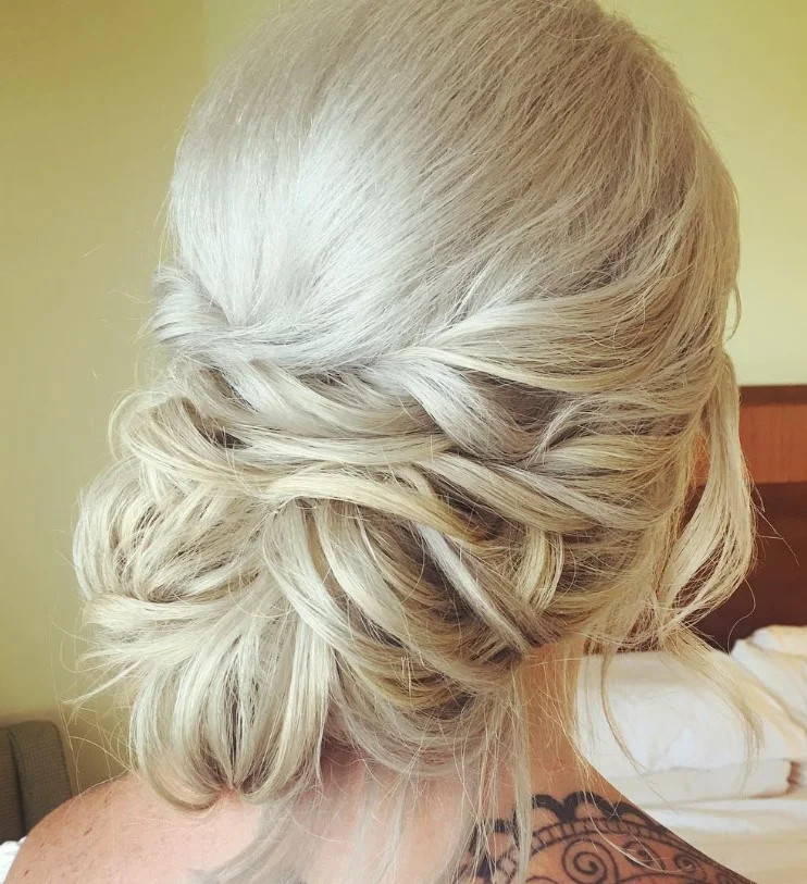 messy low beach updo hairstyle with soft loose texture