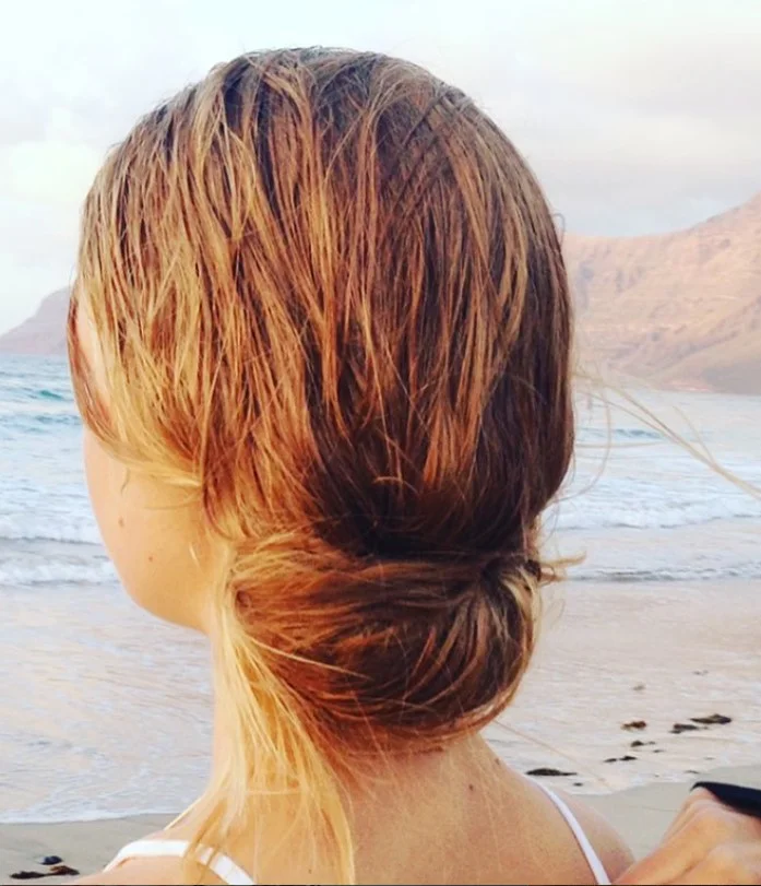sleek wet look beach updo hairstyle for modern summer hair