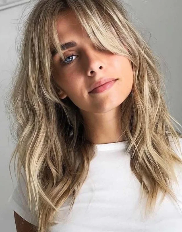 curtain bangs and beach waves hairstyle for long hair summer trend