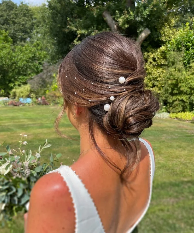 romantic curly low bun hairstyle for beach wedding event