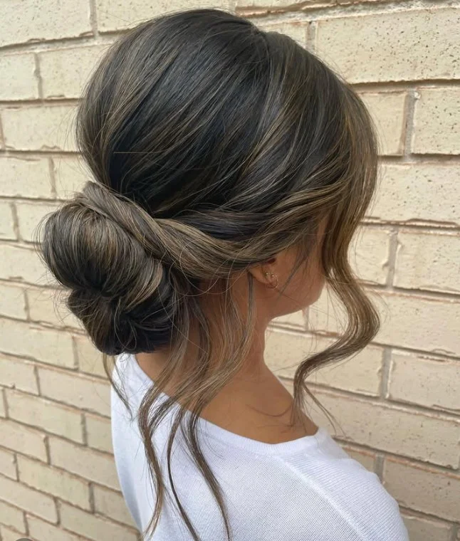 textured messy low bun hairstyle for beach wedding guest